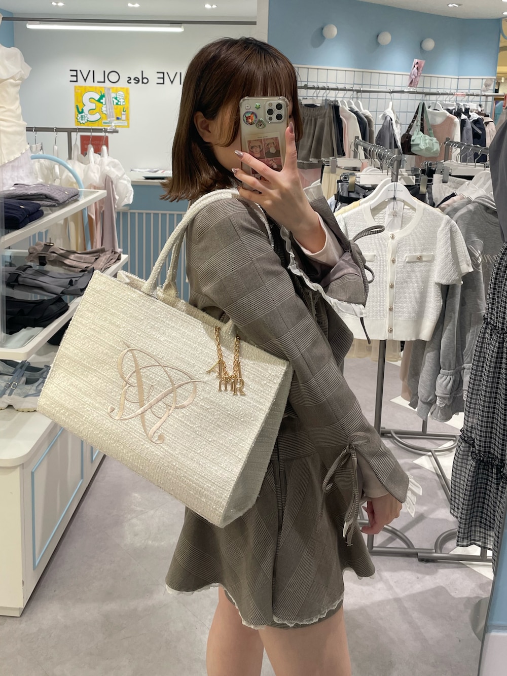 ホワイト系のトートバッグ、ブラウン系のテーラードジャケット、ブラウン系のスカートを着用したレディースの春コーディネートの2枚目の写真