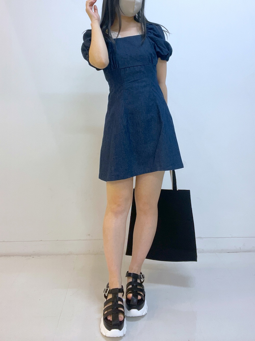 ブルー系のワンピース、ブラック系のサンダル、ブラック系のトートバッグを着用したレディースの春コーディネートの3枚目の写真