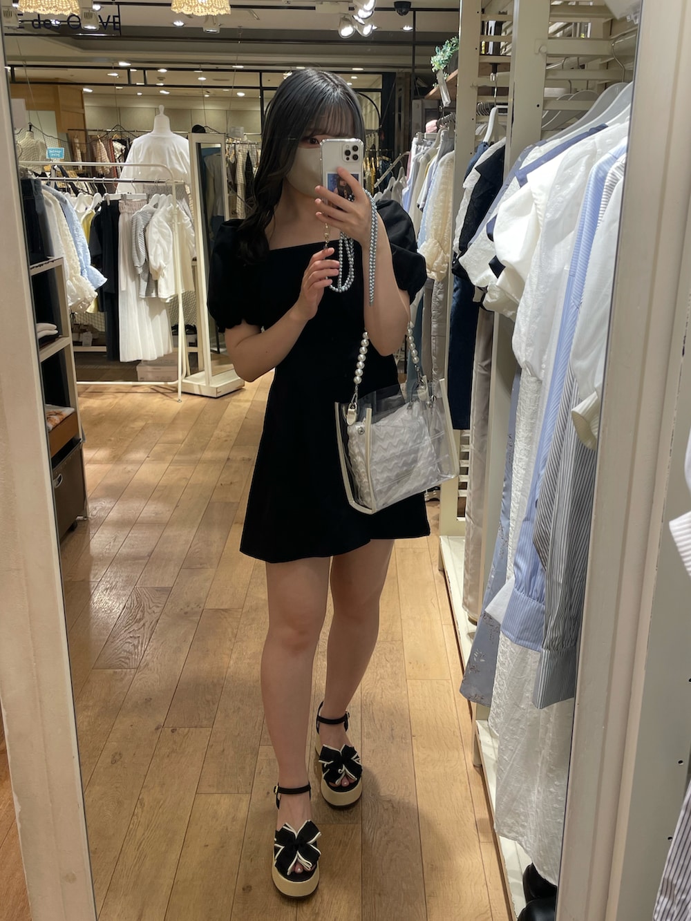 ブラック系のワンピース、ホワイト系のショルダーバッグを着用したレディースの春コーディネートの2枚目の写真