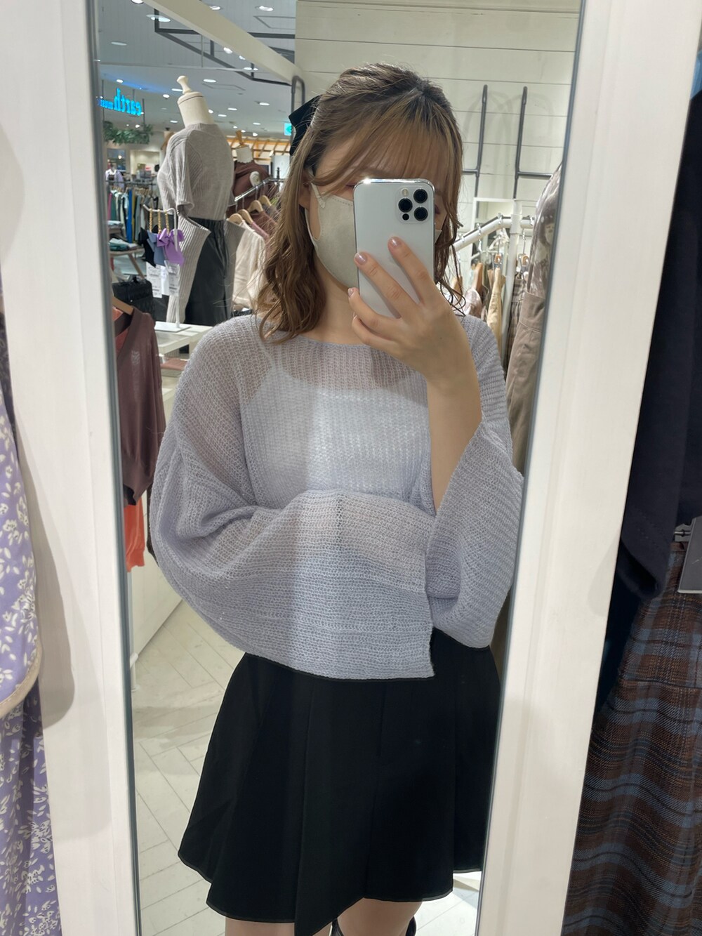 ブラック系のスカート、ブルー系のニット/セーター、ブラック系のブーツを着用したレディースの夏コーディネートの2枚目の写真