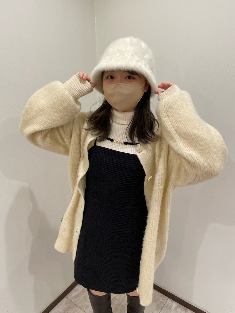 ブラック系のワンピース、ホワイト系のニット/セーター、ベージュ系のカーディガン/ボレロを着用したレディースの秋コーディネートの2枚目の写真