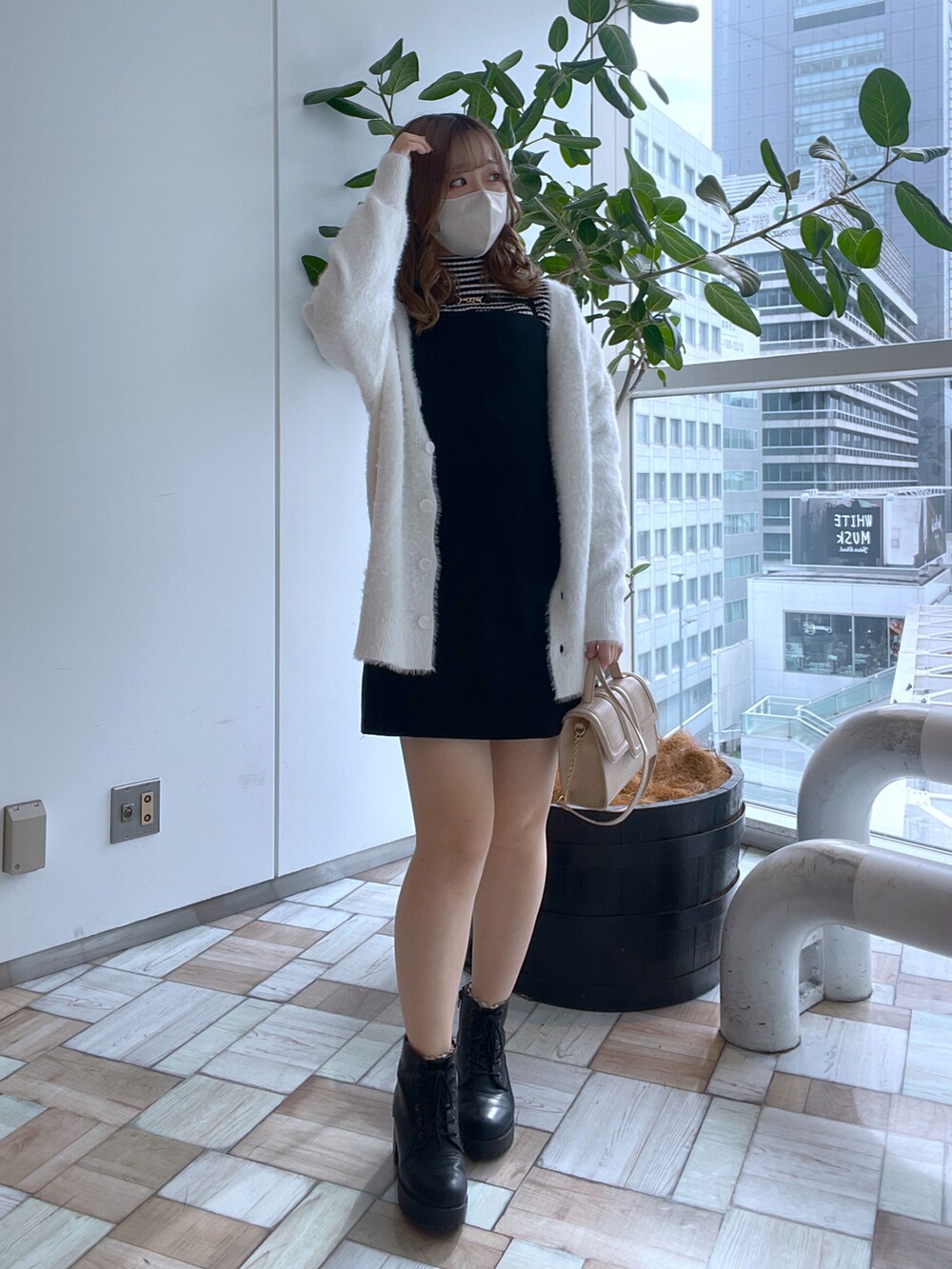 ホワイト系のショルダーバッグ、ホワイト系のカーディガン/ボレロ、ブラック系のニット/セーターを着用したレディースの秋コーディネートの2枚目の写真