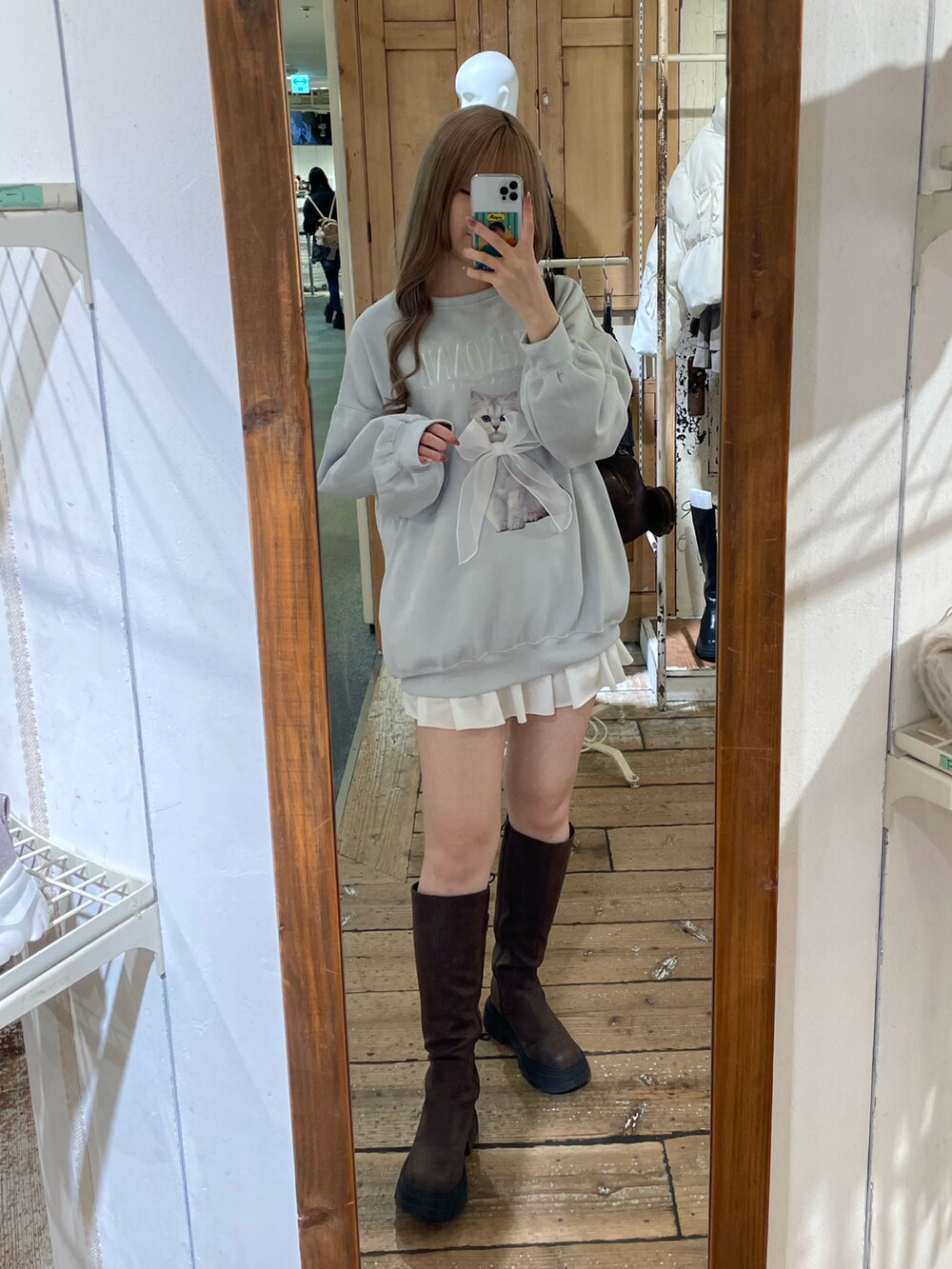 ブルー系のTシャツ/カットソー、ホワイト系のスカート、ブラウン系のブーツを着用したレディースの秋コーディネートの2枚目の写真