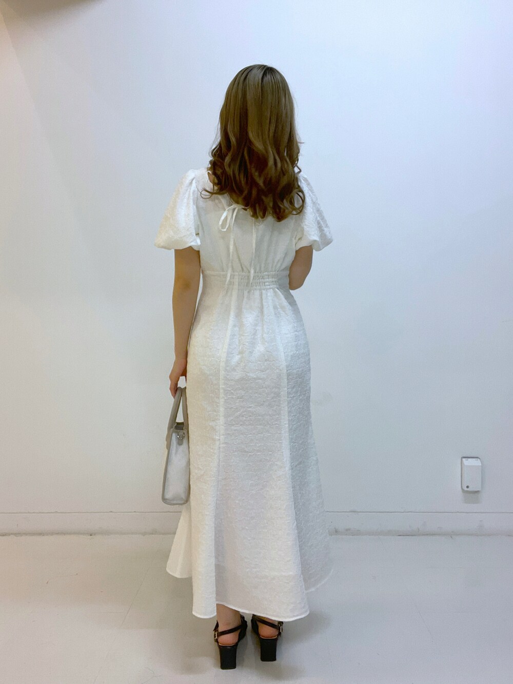 ホワイト系のワンピースを着用したレディースの春コーディネートの2枚目の写真