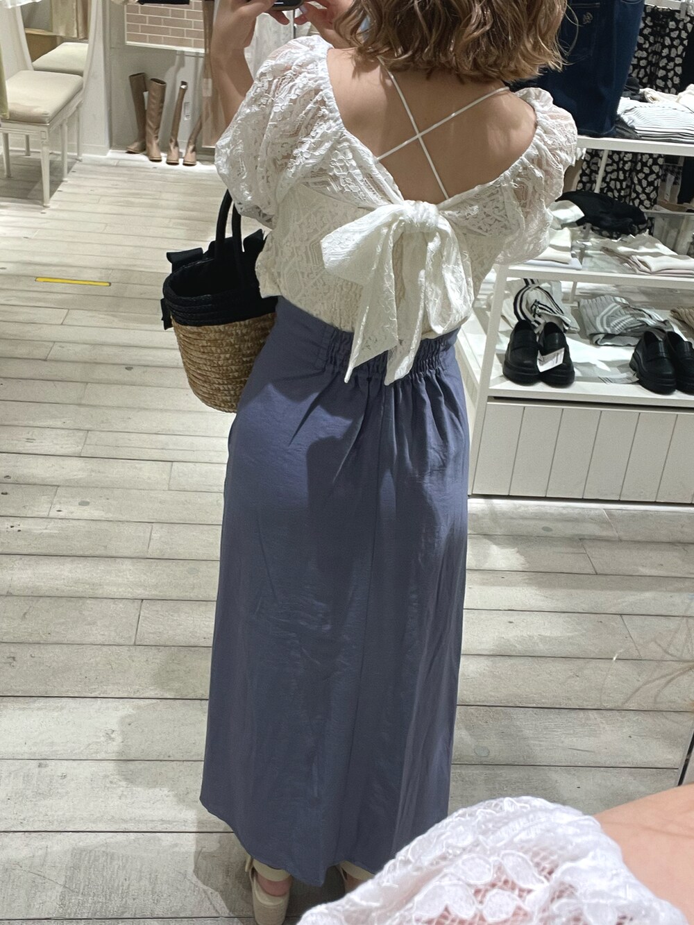 ブラック系のかごバッグ、ブルー系のスカート、ホワイト系のシャツ/ブラウスを着用したレディースの春コーディネートの2枚目の写真