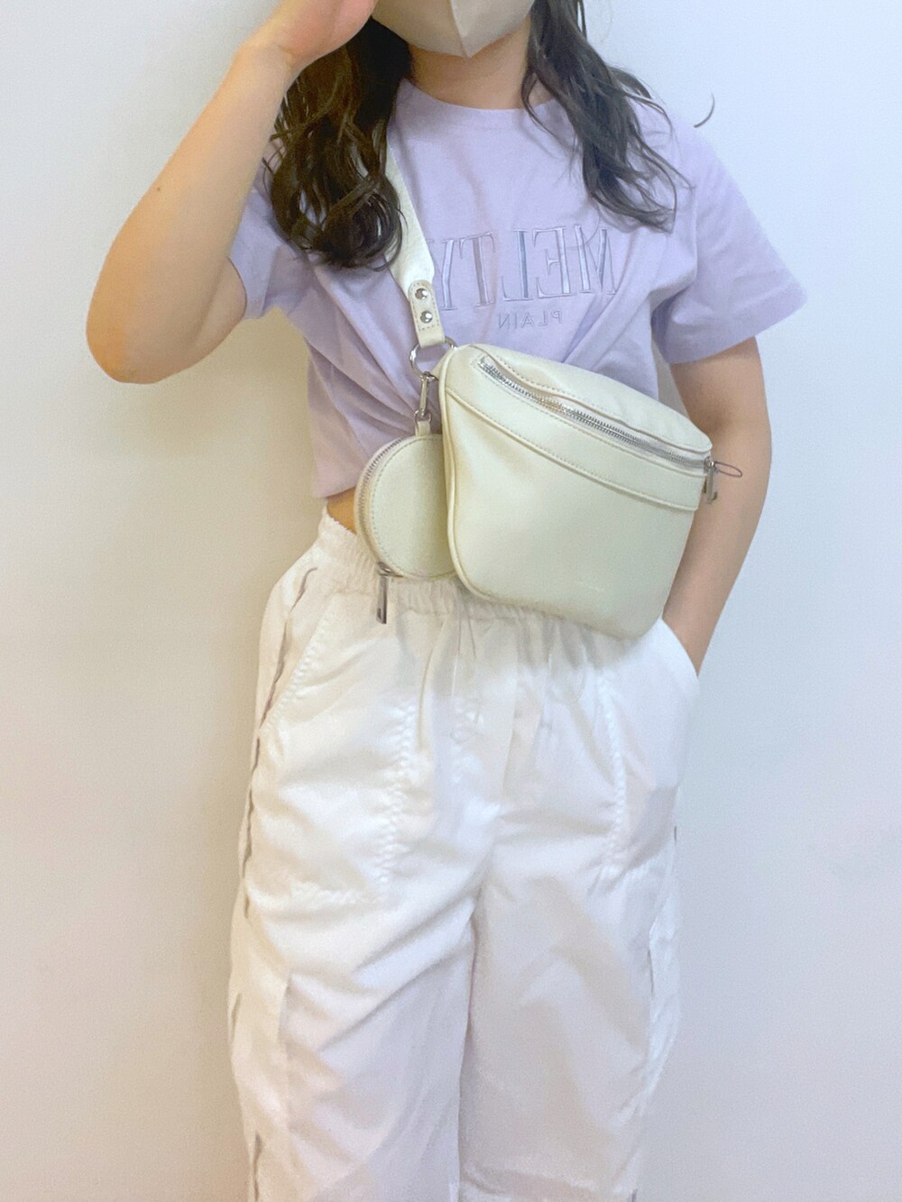 ホワイト系のカーゴパンツ、ホワイト系のボディバッグ/ウエストポーチ、パープル系のTシャツ/カットソーを着用したレディースの春コーディネートの2枚目の写真