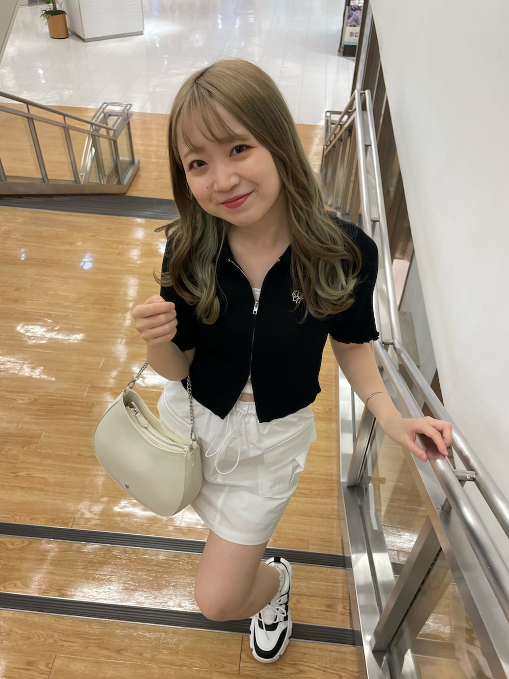 ホワイト系のショルダーバッグ、ホワイト系のスカート、ホワイト系のスニーカーを着用したレディースの夏コーディネートの2枚目の写真