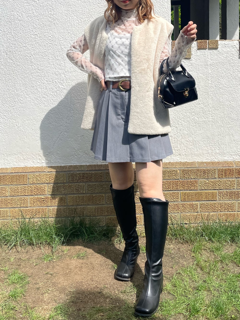 ホワイト系のTシャツ/カットソー、グレー系のスカート、ホワイト系のその他アウターを着用したレディースの秋コーディネートの2枚目の写真