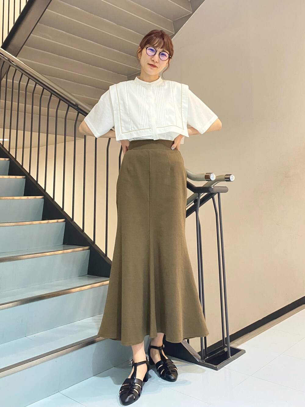ホワイト系のシャツ/ブラウス、ブラウン系のスカート、ブラック系のサンダルを着用したレディースの夏コーディネートの2枚目の写真