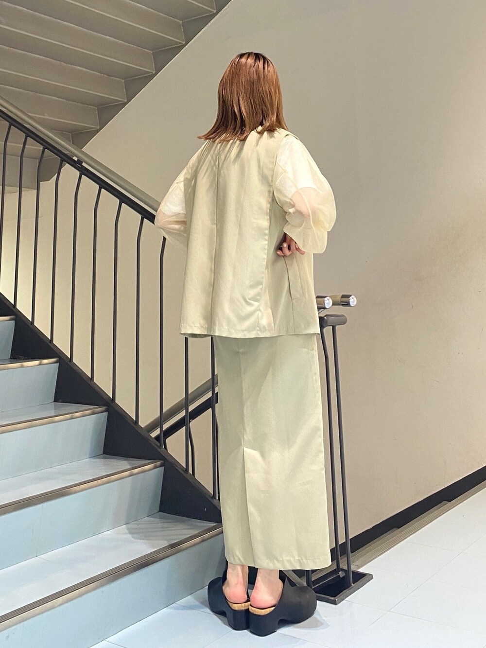 ホワイト系のニット/セーター、ベージュ系のワンピース、ホワイト系のTシャツ/カットソーを着用したレディースの春コーディネートの5枚目の写真