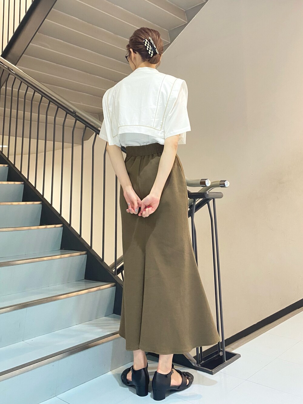 ホワイト系のシャツ/ブラウス、ブラウン系のスカート、ブラック系のサンダルを着用したレディースの夏コーディネートの3枚目の写真