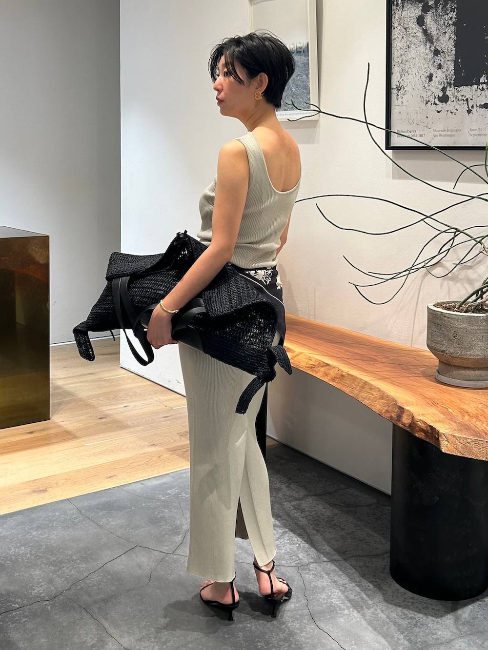 グレー系のタンクトップ、ブラック系のブルゾン、グレー系のスカートを着用したレディースの春コーディネートの4枚目の写真