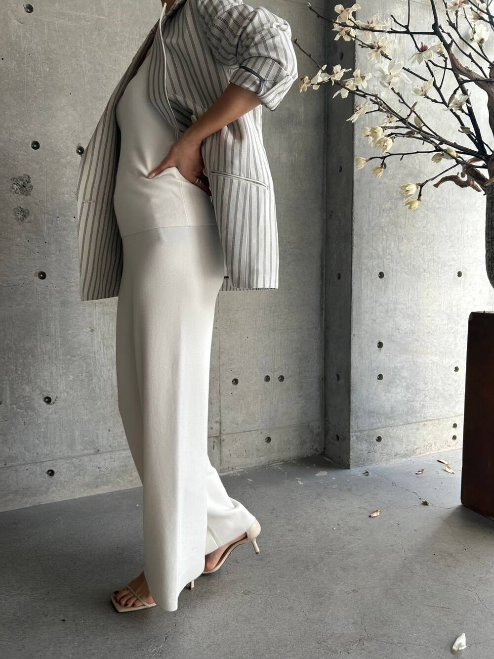 ホワイト系のその他パンツ、ホワイト系のタンクトップ、ベージュ系のサンダルを着用したレディースの冬コーディネートの7枚目の写真