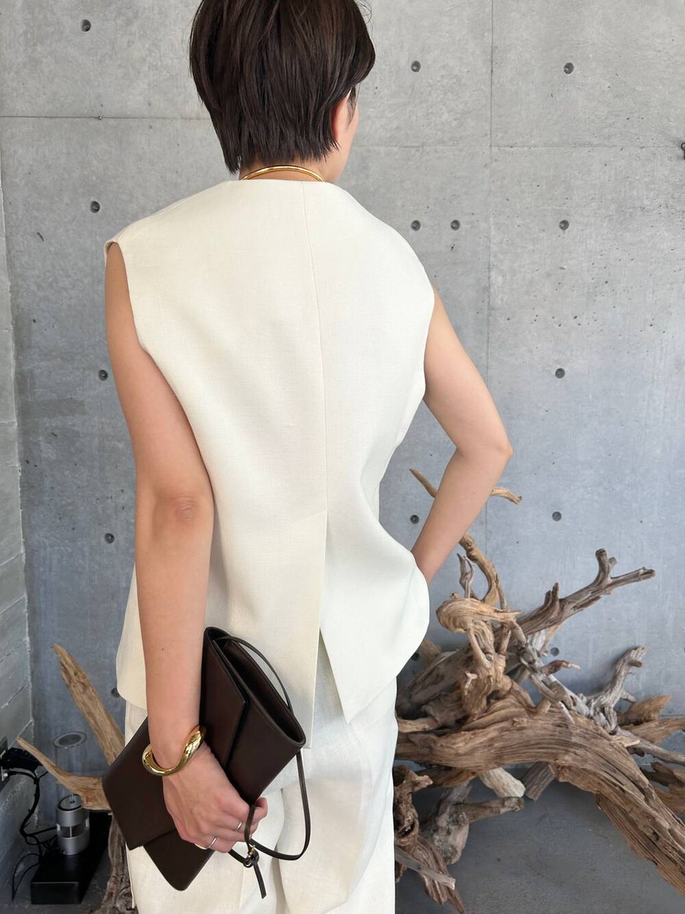 ブルー系のキャミソール、ベージュ系のサンダル、ホワイト系のスラックスを着用したレディースの夏コーディネートの6枚目の写真