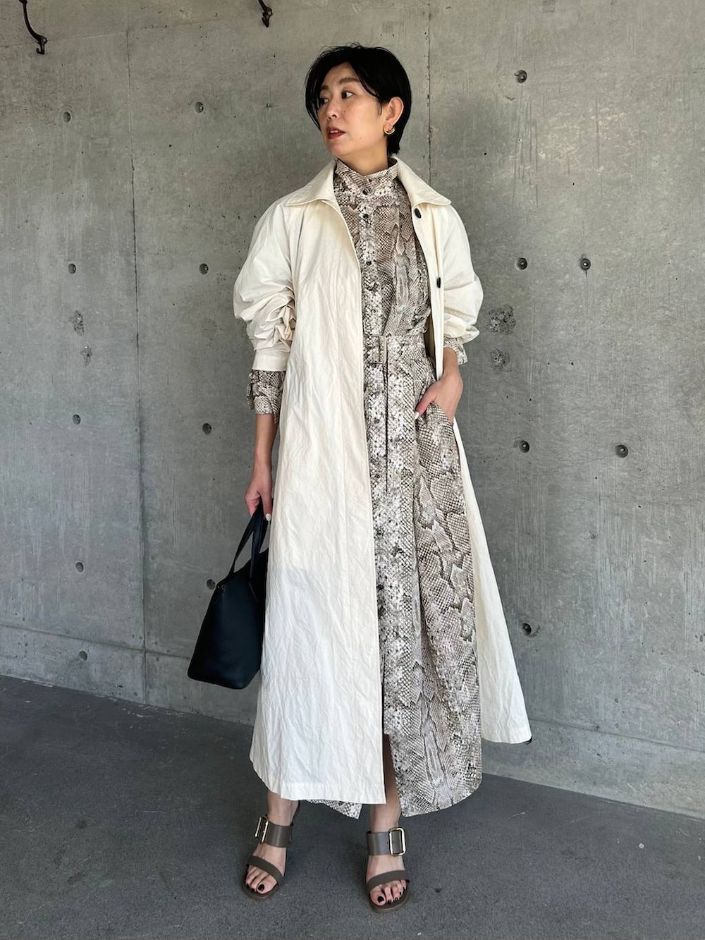 ホワイト系のステンカラーコート、ベージュ系のワンピースを着用したレディースの春コーディネートの5枚目の写真