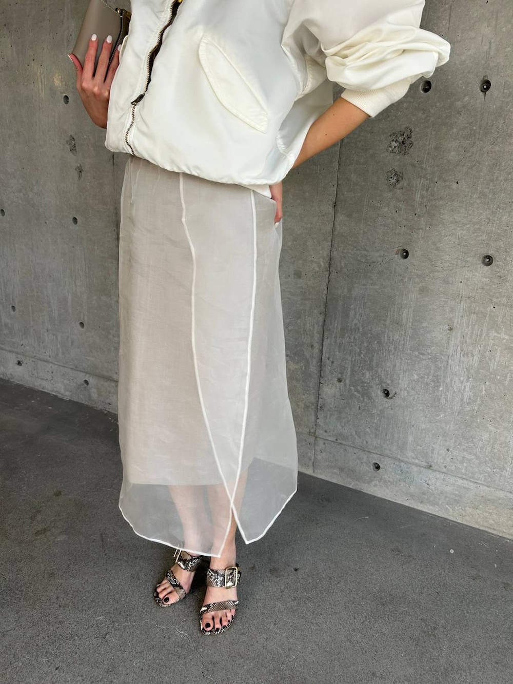 ベージュ系のスカート、ホワイト系のMA-1を着用したレディースの春コーディネートの8枚目の写真