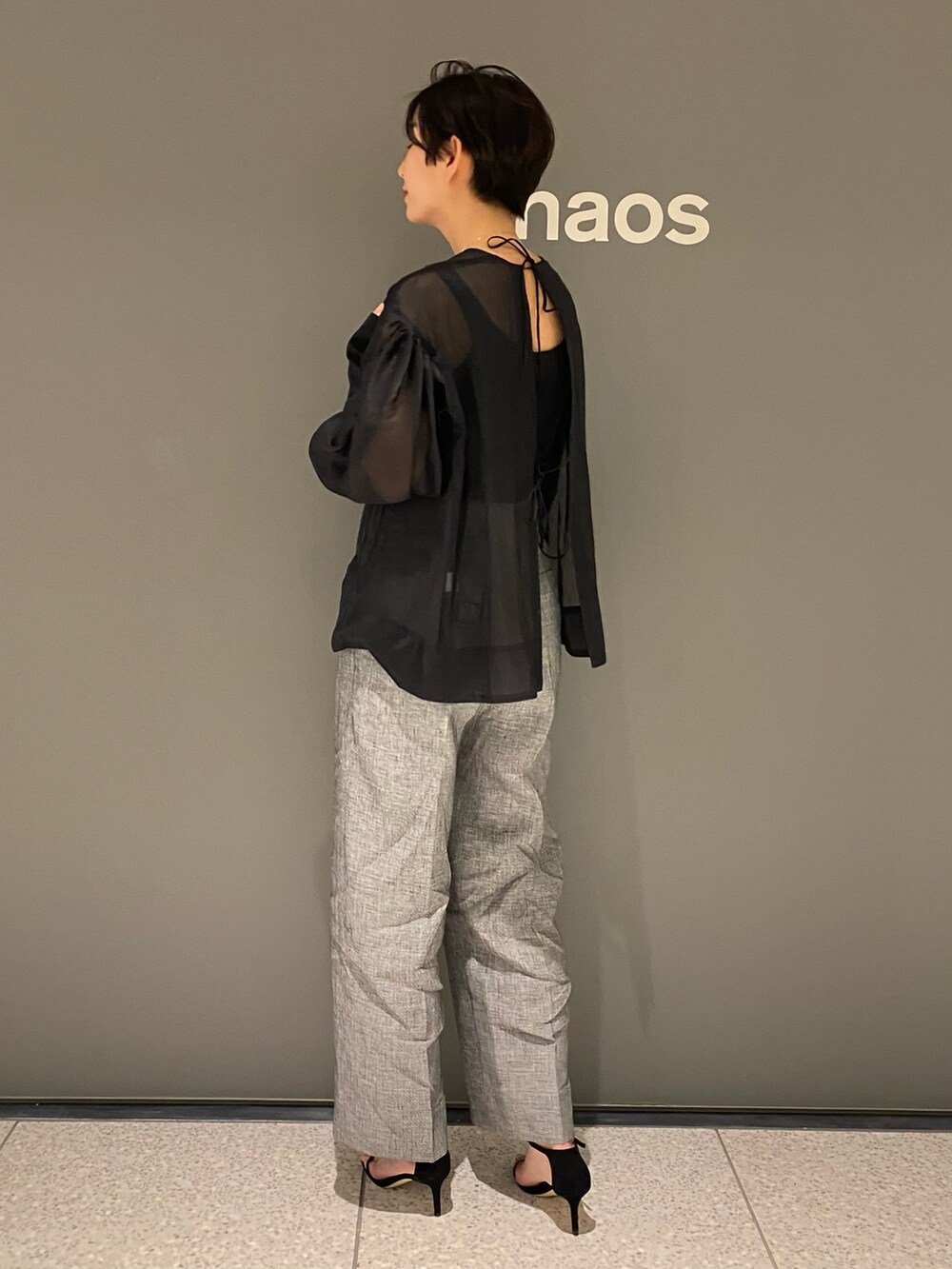 ブラック系のシャツ/ブラウス、ブラック系のタンクトップ、グレー系のパンツを着用したレディースの春コーディネートの4枚目の写真