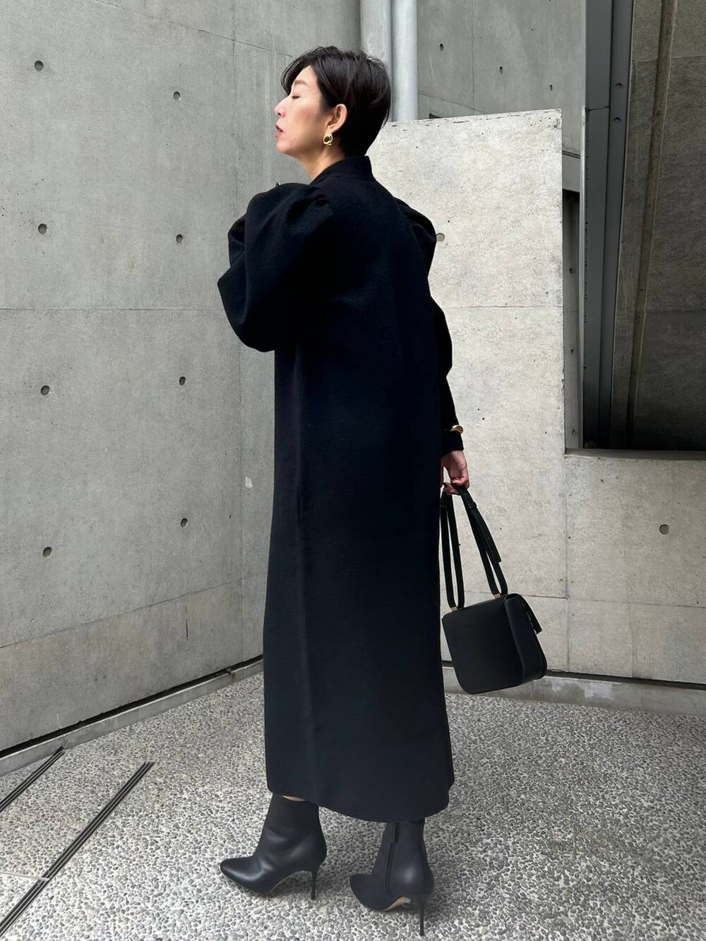 ブラック系のワンピースを着用したレディースの秋コーディネートの3枚目の写真