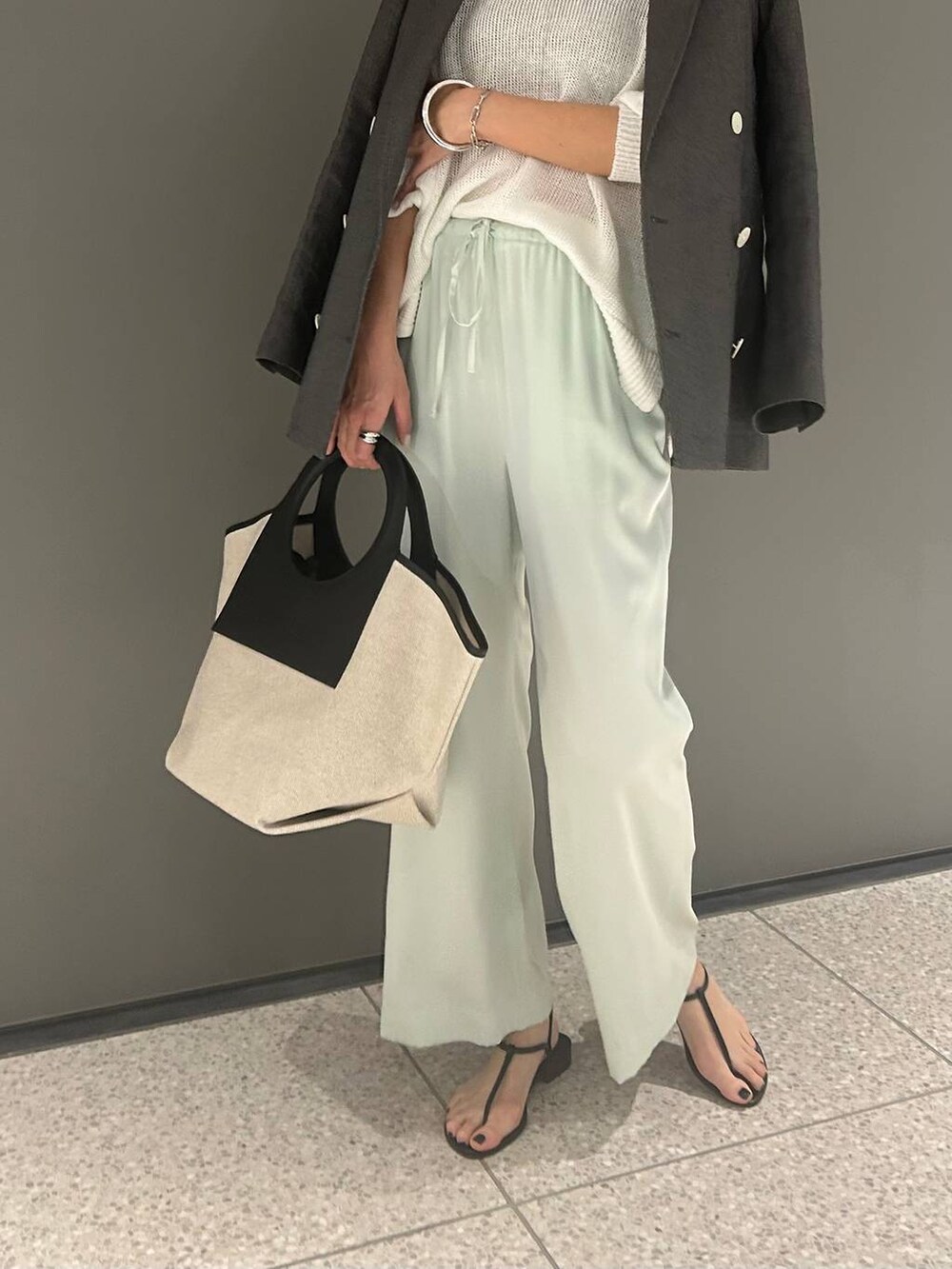 グリーン系のその他パンツ、ホワイト系のニット/セーター、ブラック系のテーラードジャケットを着用したレディースの春コーディネートの9枚目の写真