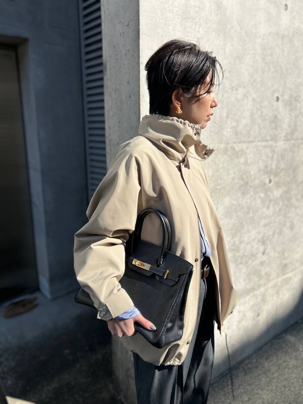 グレー系のニット/セーター、ブルー系のシャツ/ブラウス、グレー系のスラックスを着用したレディースの冬コーディネートの7枚目の写真