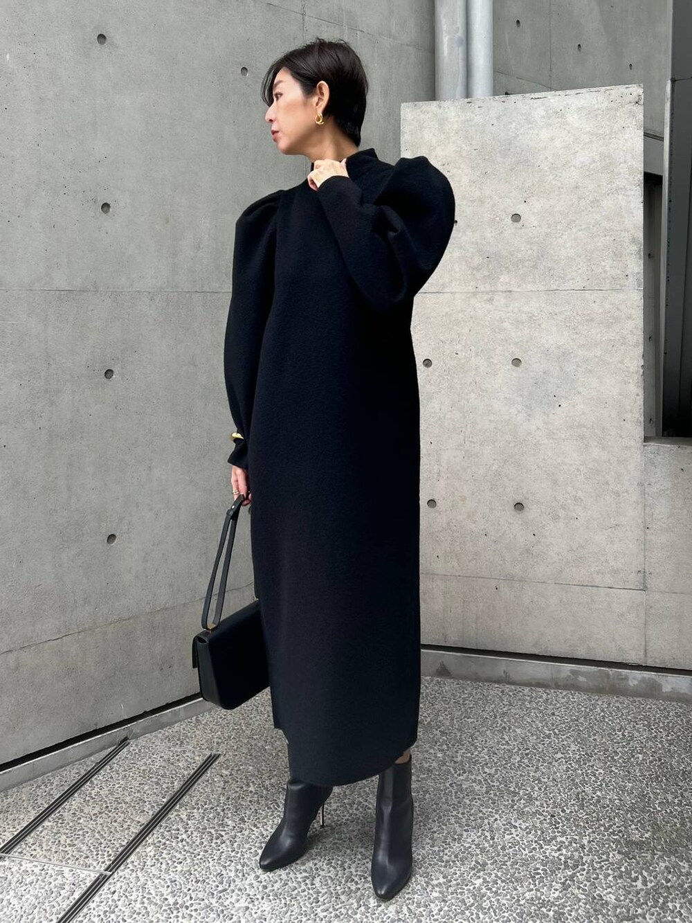 ブラック系のワンピースを着用したレディースの秋コーディネートの2枚目の写真