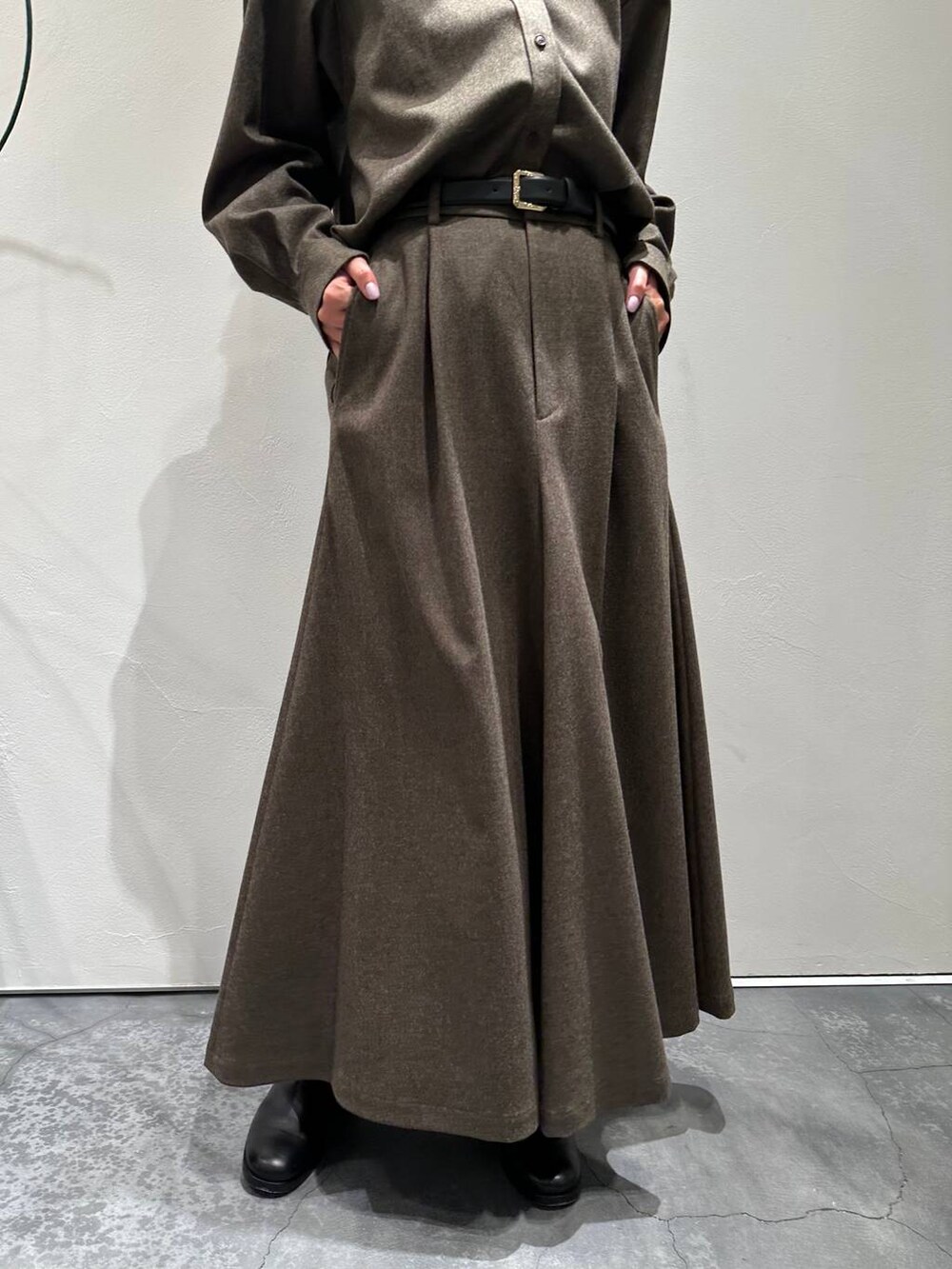ブルー系のカーディガン/ボレロ、ブラック系のブーツ、ブラウン系のスカートを着用したレディースの冬コーディネートの8枚目の写真