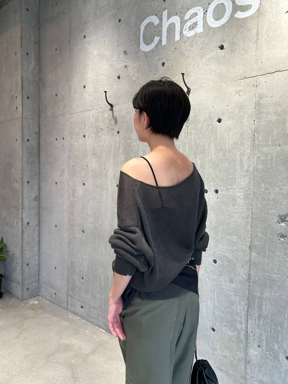 ブラック系のチューブトップ、グリーン系のニット/セーター、グリーン系のスラックスを着用したレディースの春コーディネートの7枚目の写真