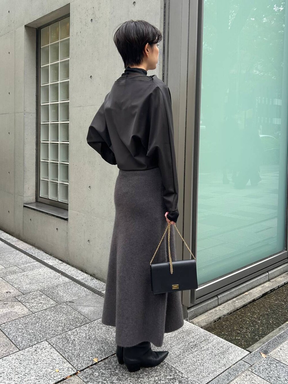 ブラック系のその他トップス、ブラック系のノーカラーコート、グレー系のスカートを着用したレディースの秋コーディネートの4枚目の写真
