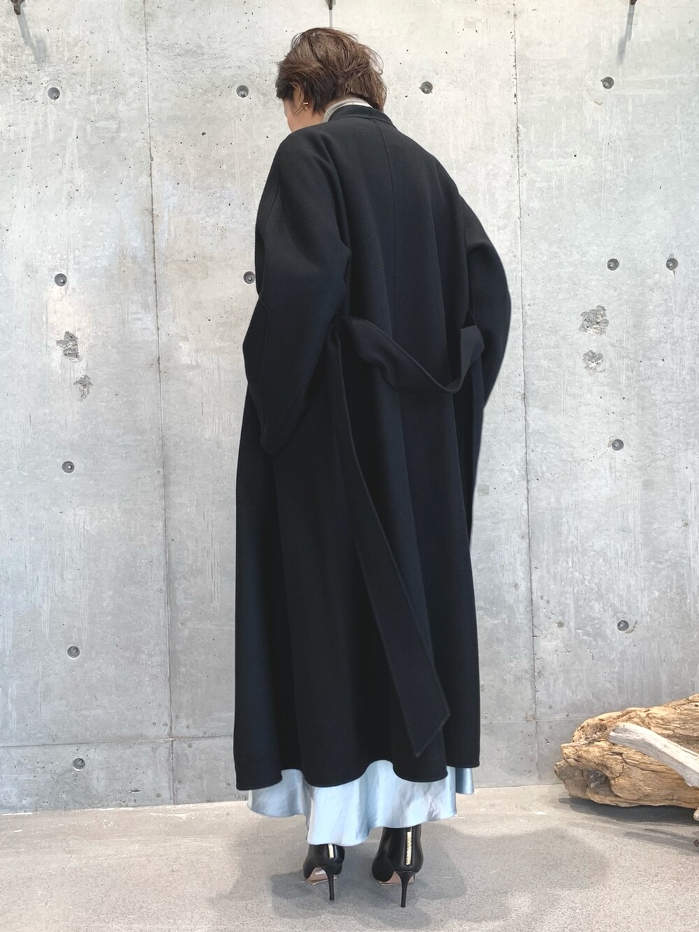 ブラック系のジャケット/アウター、ベージュ系のニット/セーター、グリーン系のスカートを着用したレディースの秋コーディネートの3枚目の写真