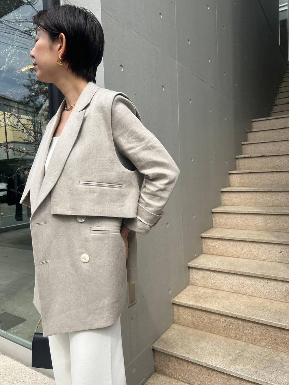ホワイト系のその他パンツ、ホワイト系のタンクトップ、ベージュ系のナイロンジャケットを着用したレディースの春コーディネートの7枚目の写真