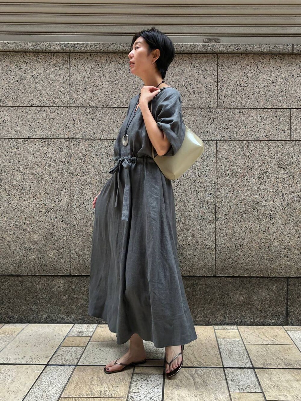 グリーン系のワンピース、グリーン系のサンダル、グレー系のネックレスを着用したレディースの夏コーディネートの3枚目の写真