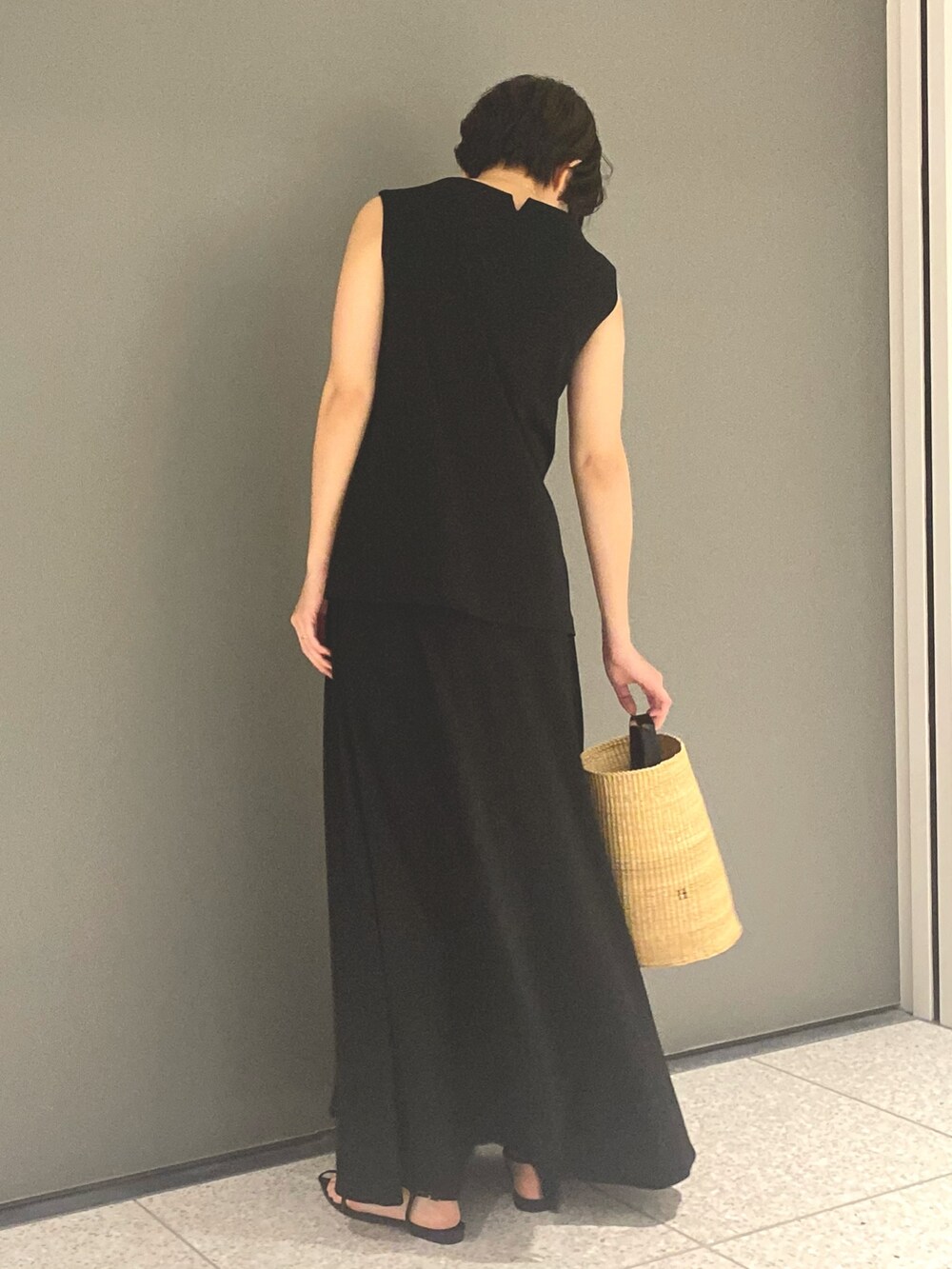 ブラック系のTシャツ/カットソー、ブラック系のスカート、ブラック系のサンダルを着用したレディースの春コーディネートの3枚目の写真