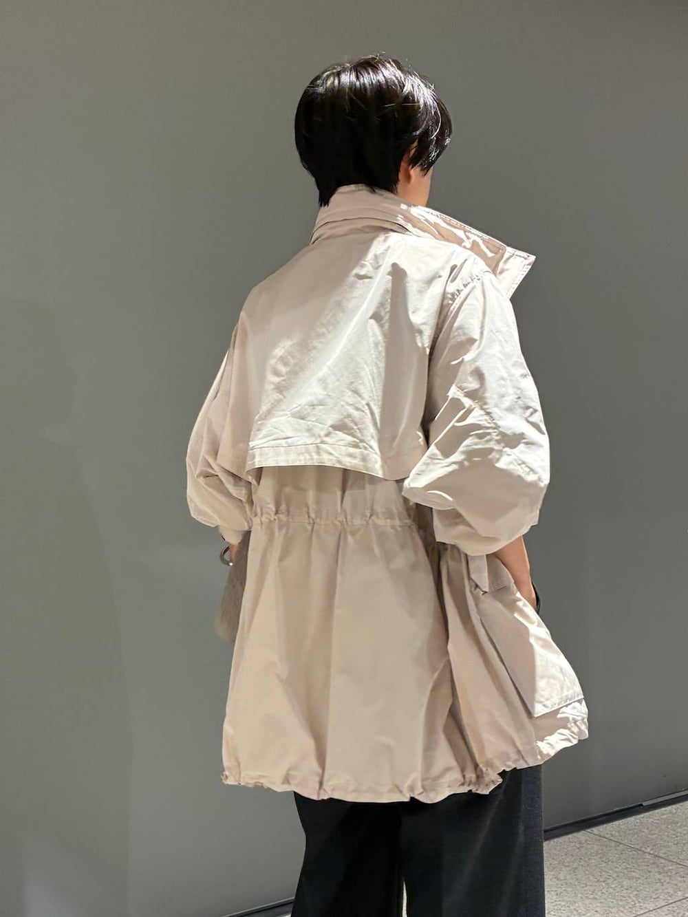 グレー系のスラックス、ピンク系のブルゾン、ブラック系のベルトを着用したレディースの夏コーディネートの8枚目の写真