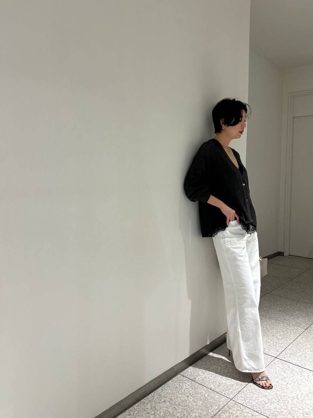 グリーン系のカーディガン/ボレロ、ホワイト系のデニムパンツ、グレー系のナイロンジャケットを着用したレディースの春コーディネートの7枚目の写真