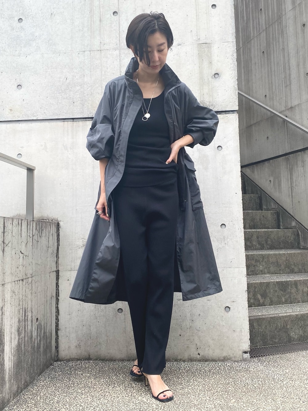 ブラック系のその他パンツ、ブラック系のタンクトップ、グレー系のナイロンジャケットを着用したレディースの夏コーディネートの2枚目の写真