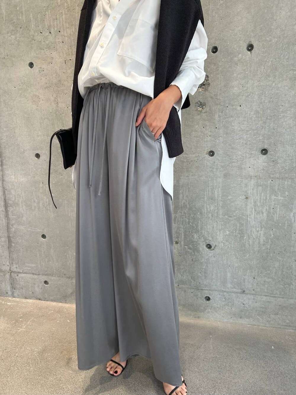 グレー系のその他パンツ、ブラック系のサンダル、グレー系のニット/セーターを着用したレディースの秋コーディネートの4枚目の写真