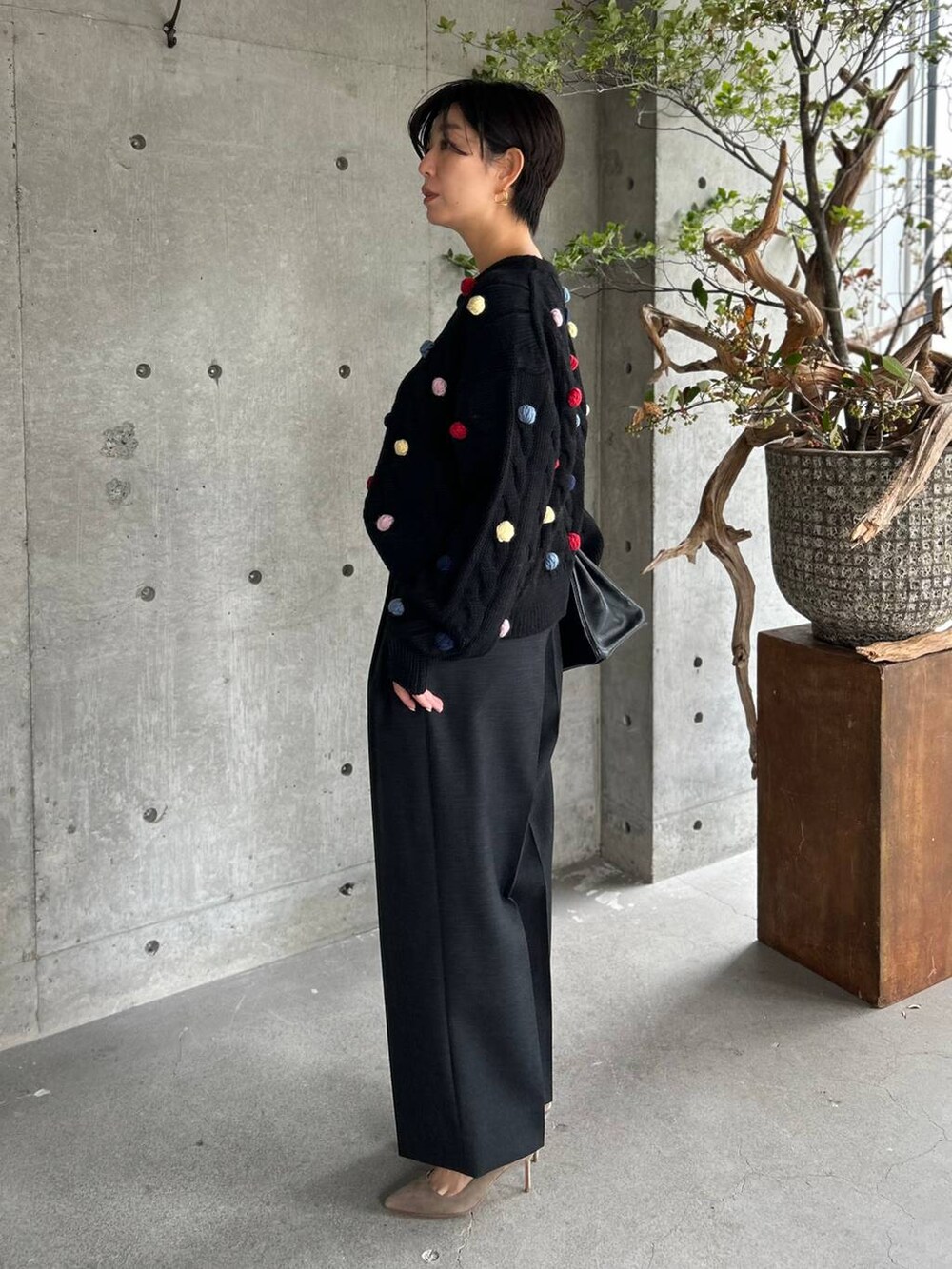 グレー系のスラックス、ブラック系のニット/セーター、ブラウン系のベルトを着用したレディースの秋コーディネートの3枚目の写真