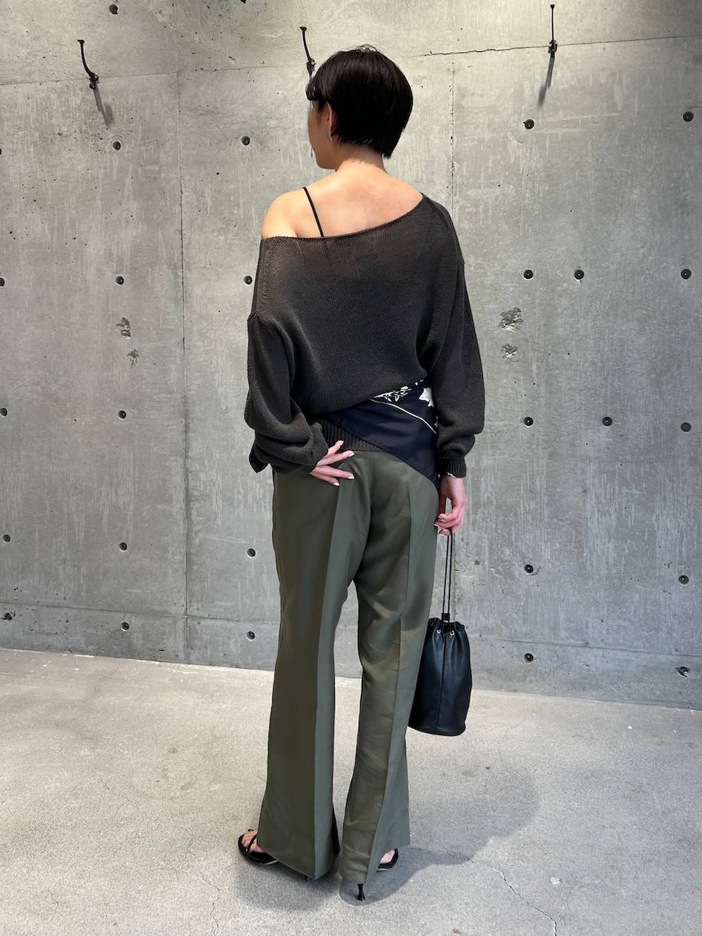 ブラック系のチューブトップ、グリーン系のニット/セーター、グリーン系のスラックスを着用したレディースの春コーディネートの5枚目の写真