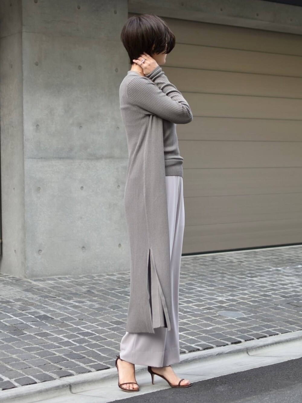 グレー系のタンクトップ、ピンク系のスラックス、グレー系のカーディガン/ボレロを着用したレディースの冬コーディネートの2枚目の写真