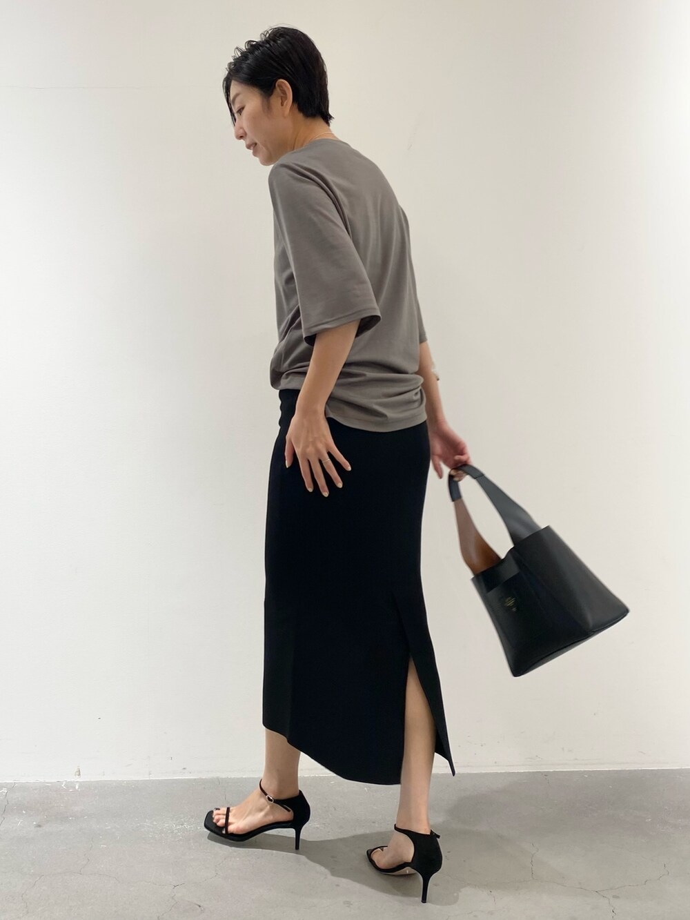 ブラウン系のTシャツ/カットソー、ブラック系のスカート、ブラック系のサンダルを着用したレディースの夏コーディネートの3枚目の写真