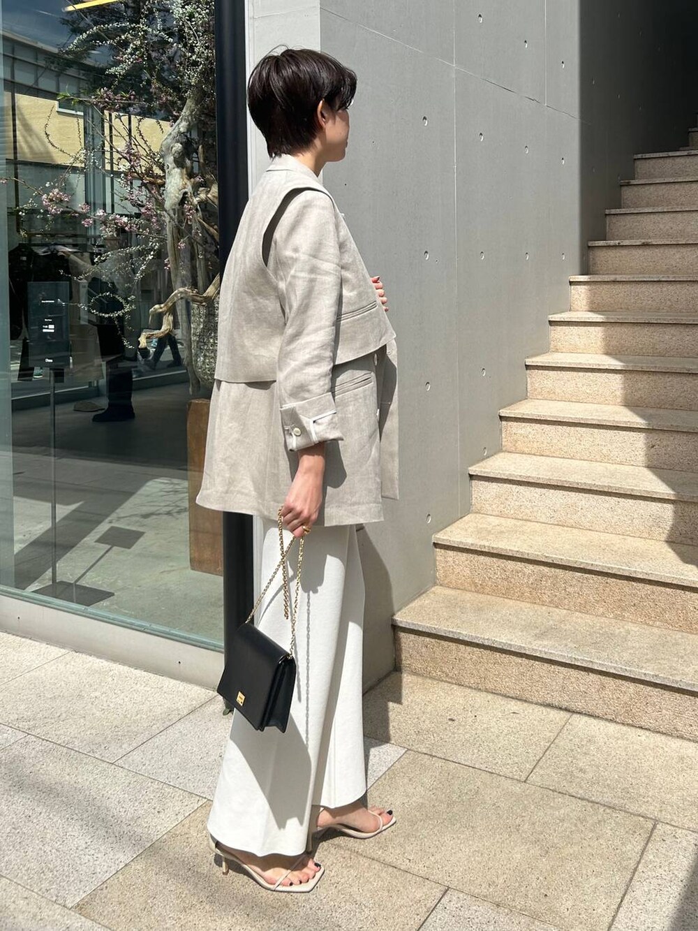 ホワイト系のその他パンツ、ホワイト系のタンクトップ、ベージュ系のナイロンジャケットを着用したレディースの春コーディネートの5枚目の写真