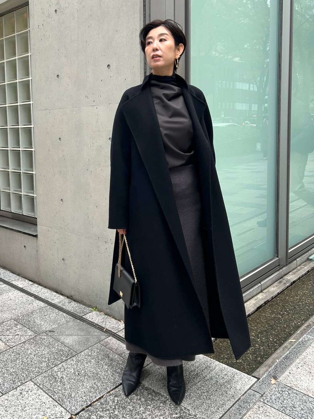 ブラック系のその他トップス、ブラック系のノーカラーコート、グレー系のスカートを着用したレディースの秋コーディネートの7枚目の写真