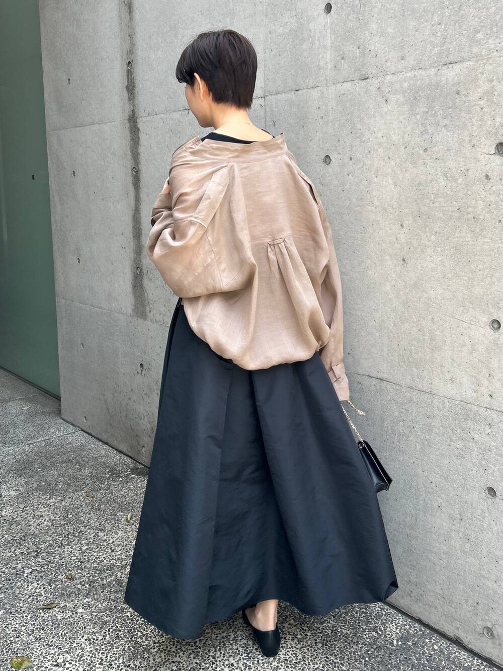 グレー系のブルゾン、ブラック系のスカート、ブラウン系のニット/セーターを着用したレディースの春コーディネートの6枚目の写真