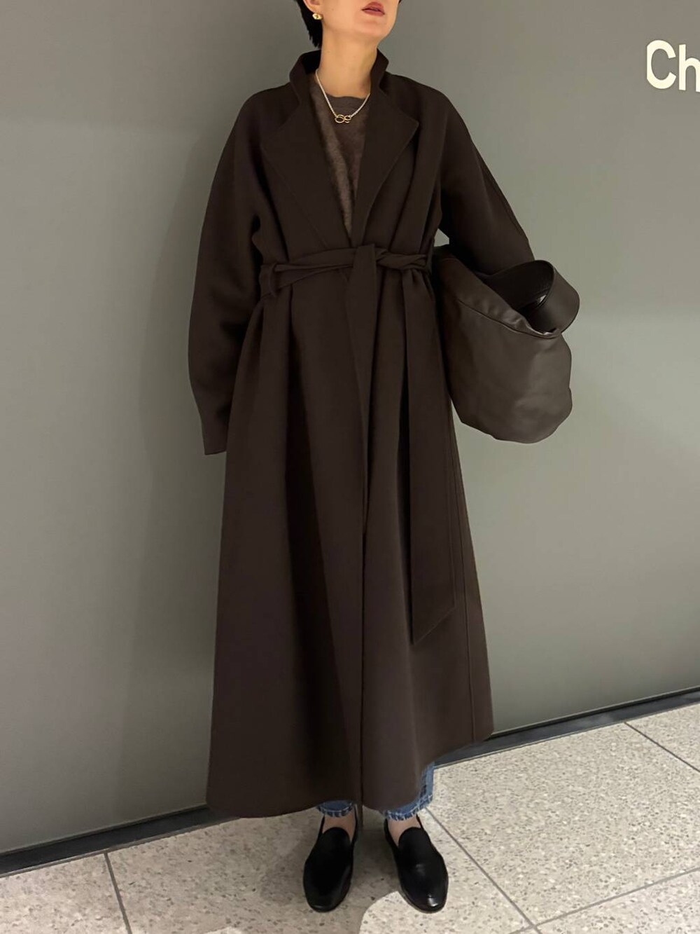 ブルー系のデニムパンツ、ブラウン系のニット/セーター、ブラウン系のノーカラーコートを着用したレディースの秋コーディネートの6枚目の写真