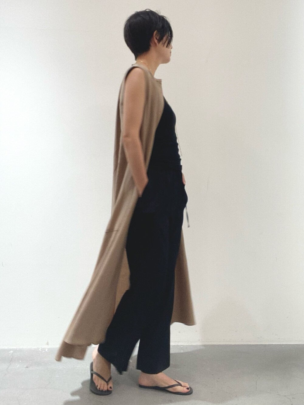 イエロー系のワンピース、ブラック系のタンクトップ、ブラック系のその他パンツを着用したレディースの夏コーディネートの2枚目の写真