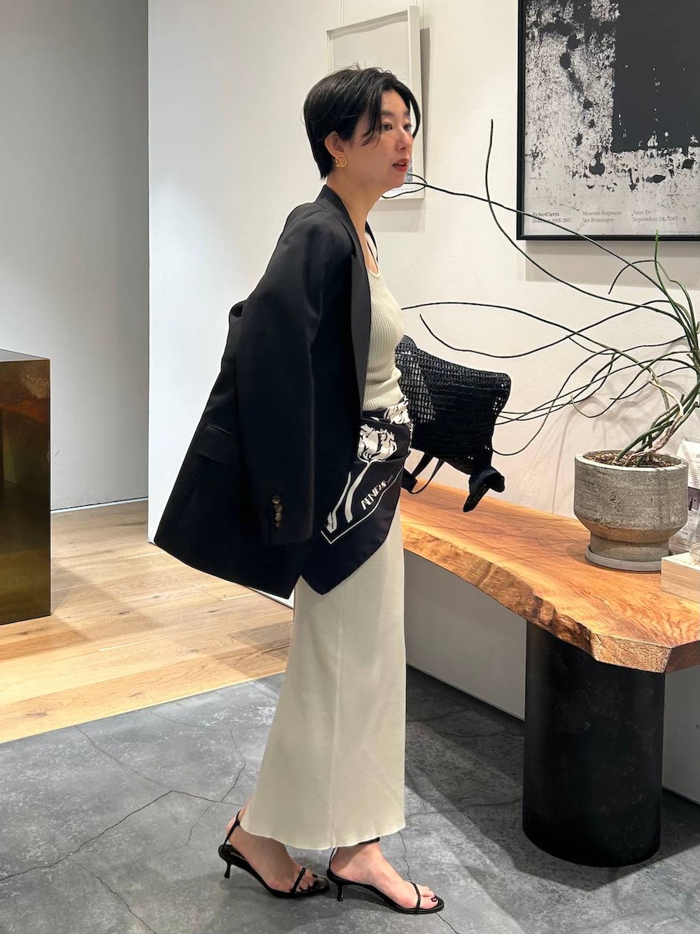 グレー系のタンクトップ、ブラック系のブルゾン、グレー系のスカートを着用したレディースの春コーディネートの7枚目の写真