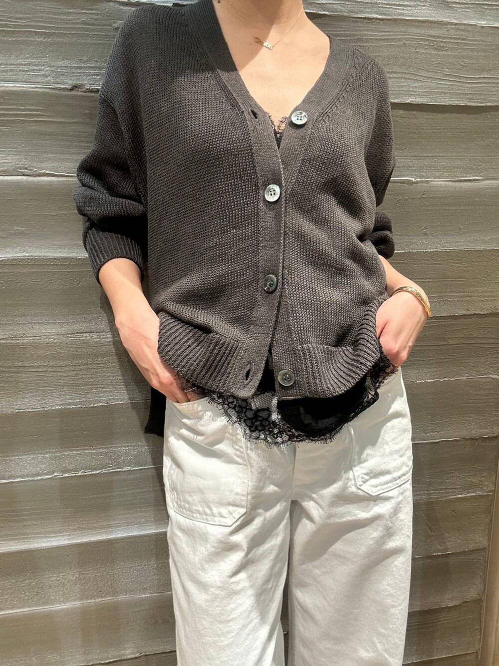 グリーン系のカーディガン/ボレロ、ホワイト系のデニムパンツ、グレー系のナイロンジャケットを着用したレディースの春コーディネートの6枚目の写真