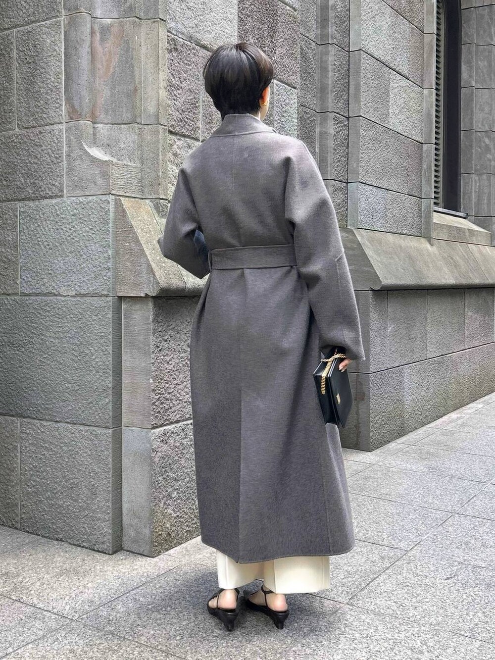 ブラウン系のノーカラーコート、ホワイト系のスラックス、ホワイト系のシャツ/ブラウスを着用したレディースの秋コーディネートの6枚目の写真