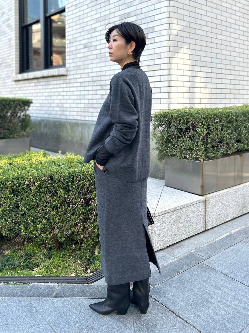 ブラック系のその他トップス、ブラック系のノーカラーコート、グレー系のカーディガン/ボレロを着用したレディースの秋コーディネートの2枚目の写真