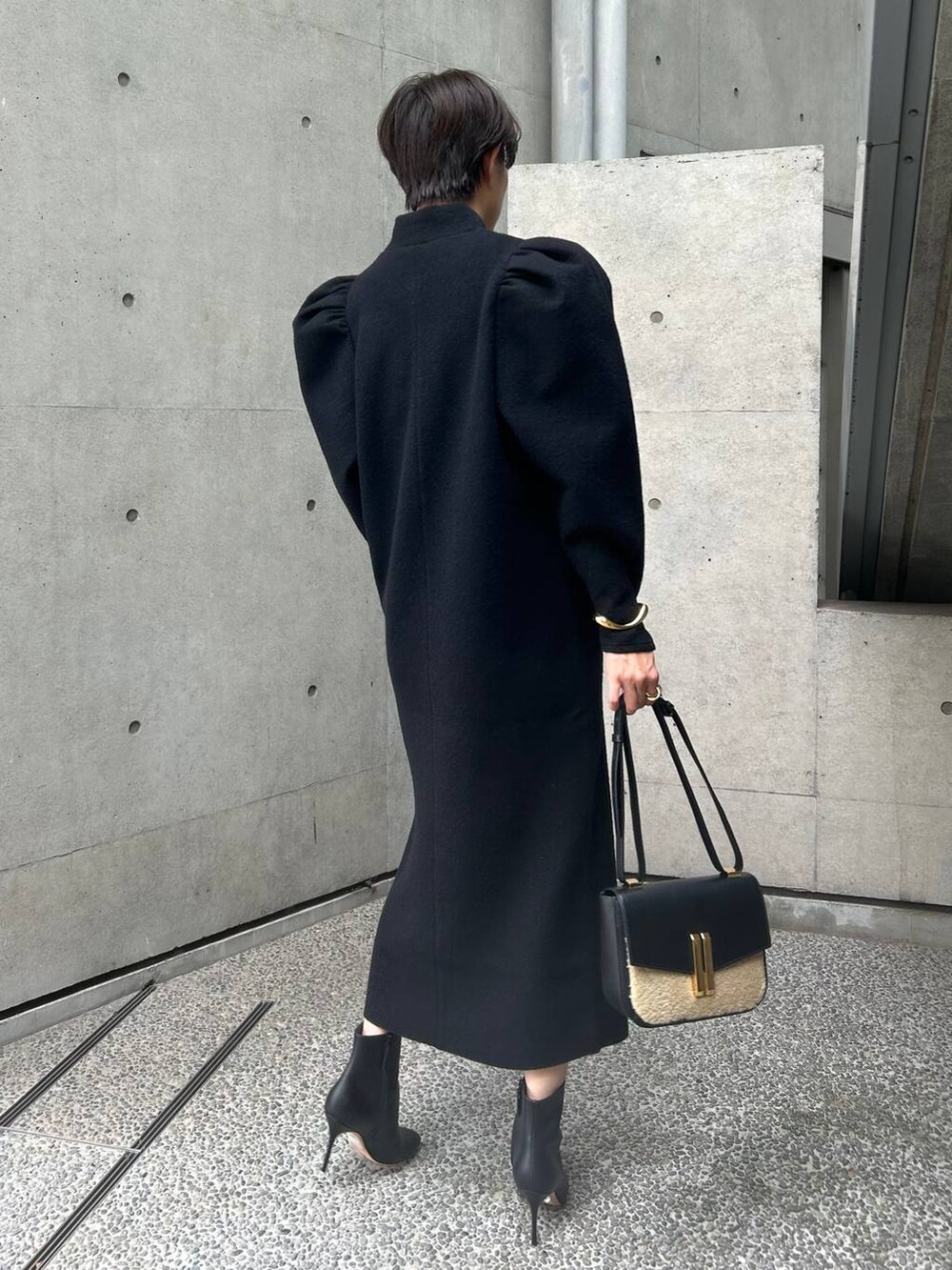 ブラック系のワンピースを着用したレディースの秋コーディネートの4枚目の写真
